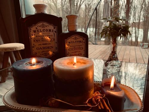a group of candles sitting on a table with bottles of whiskey at Luxury Lake House & Glamping in Teşila