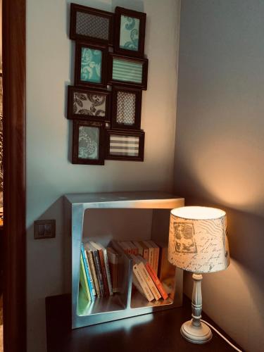 a lamp sitting on a table next to a book shelf at Luxury Lake House & Glamping in Teşila