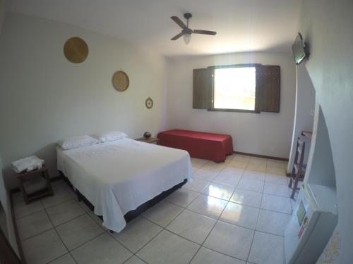 a bedroom with a white bed and a window at Topo do Cipó Ecopousada Vegana in Serra do Cipo