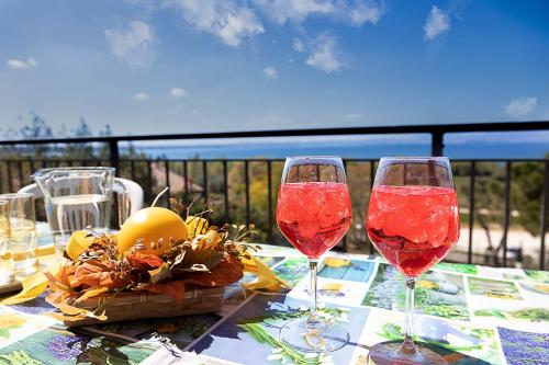 two glasses of red wine sitting on a table at APARTMENTS EDEN - Regarda Travel in Lazise