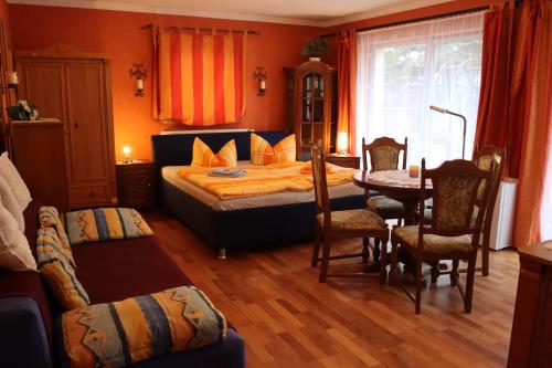 ein Schlafzimmer mit einem Bett, einem Tisch und Stühlen in der Unterkunft Haus Marcus in Kolkwitz