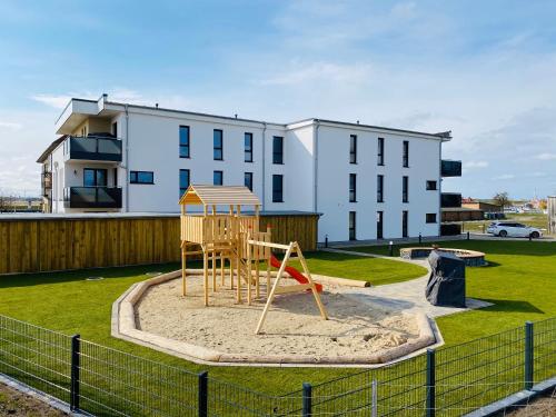 a playground in a park in front of a building at Haus Meerruhe Karlshagen Apartment 1-6 in Ostseebad Karlshagen