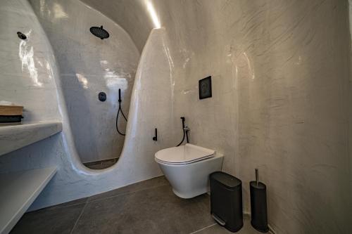 a bathroom with a toilet and a sink and a mirror at Eternity Suites Santorini in Fira