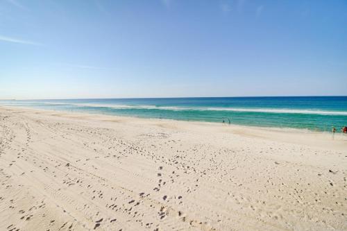 a beach with people walking on the sand and the ocean at Beachwalk Condominiums 6F in Panama City Beach