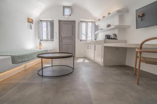 a kitchen with a table and a bed in a room at Eternity Suites Santorini in Fira