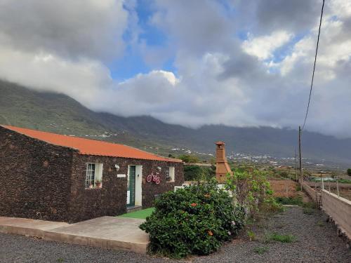 a small brick house with a mountain in the background at MI CUMANESA in Frontera