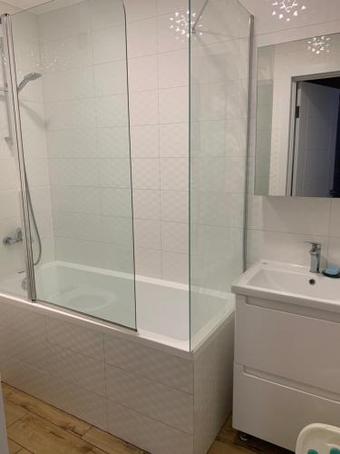 a white bathroom with a shower and a sink at Park Lake Апартаменти Центр in Ternopilʼ