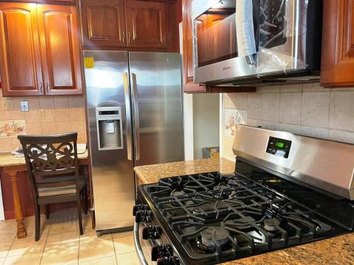 a kitchen with a stove and a stainless steel refrigerator at Governors Villa Long Island in Hempstead