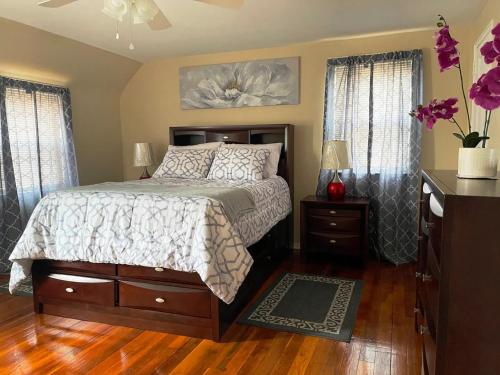 um quarto com uma cama e duas janelas em Governors Villa Long Island em Hempstead