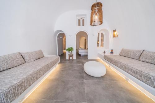 a living room with two couches and a table at Eternity Suites Santorini in Fira
