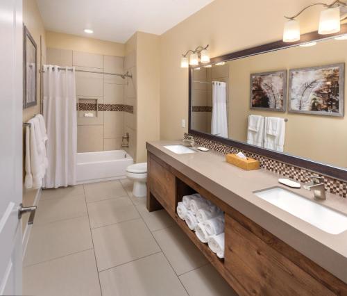 a bathroom with a sink and a toilet and a mirror at WorldMark Estancia in St. George