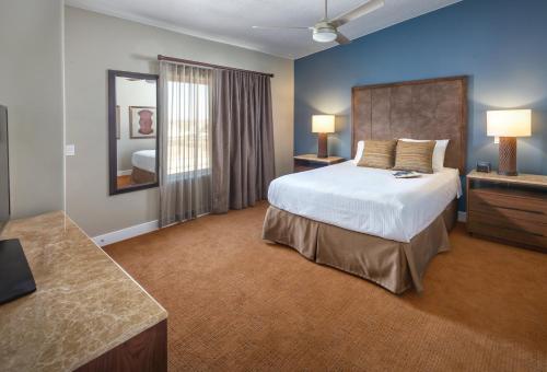a large bedroom with a bed and a mirror at WorldMark Estancia in St. George