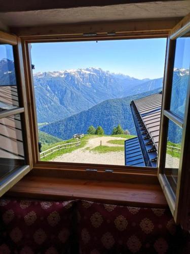 a window with a view of a mountain view at Restor Natura Malga Mondent in Pracorno di Rabbi