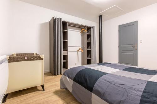 een slaapkamer met een bed en een kast bij Le Flamand, jeux en bois déco du nord! in Tourcoing
