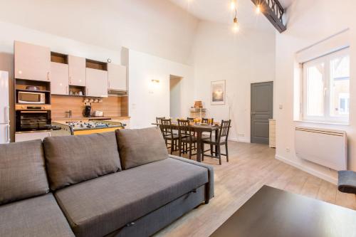 un salon avec un canapé et une cuisine dans l'établissement Le Flamand, jeux en bois déco du nord!, à Tourcoing