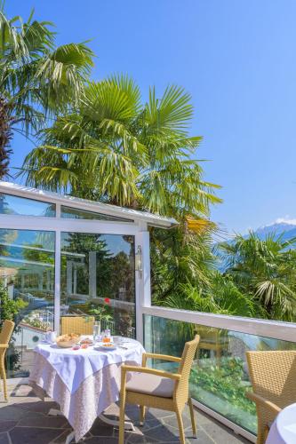 a table and chairs on a patio with a view of the ocean at Glanzhof Hotel & Apartments in Marlengo