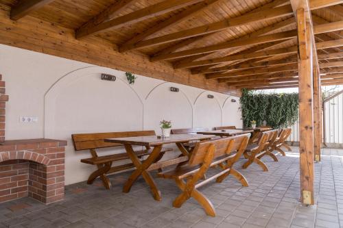 a patio with wooden tables and chairs and a fireplace at Pensiunea Transilvania in Sibiu