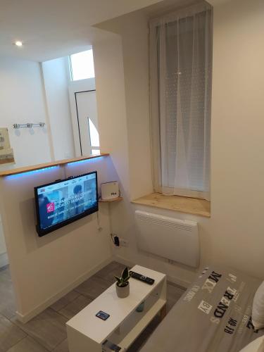 un salon avec une télévision sur un mur dans l'établissement LAN'ApparT, à Morez