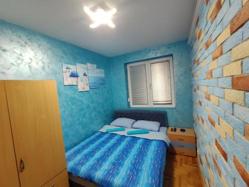 - une chambre avec un lit dans une pièce bleue dans l'établissement Modern cozy apartment, à Niš
