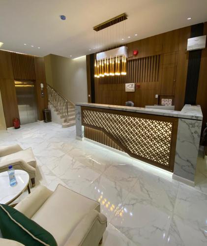Un vestíbulo de un hotel con un mostrador de recepción. en الواحة ان للشقق المخدومة, en Hotat bani tamim