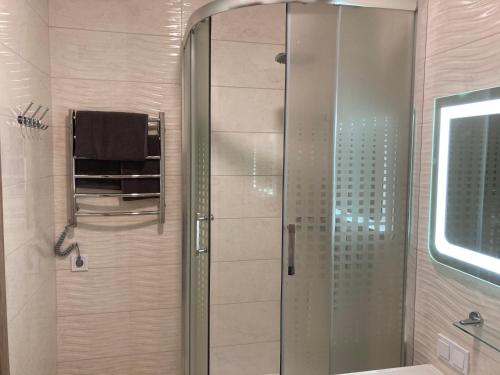 a shower with a glass door in a bathroom at Omega 6 in Odesa