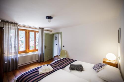 a bedroom with a large white bed and a window at LA PITA AGORDINA in Cancellade