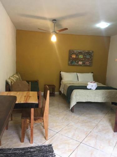 a bedroom with a bed and a table and a couch at Pousada Mar & Vida e Doçaria in Paraty