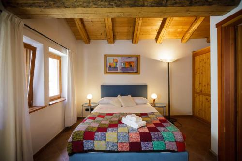 a bedroom with a bed with a colorful quilt at LA PITA AGORDINA in Cancellade