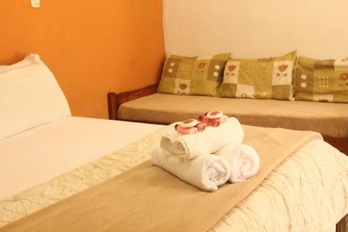 a hotel room with two beds with towels at Pousada Mar & Vida e Doçaria in Paraty