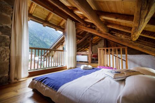a bed in a room with a large window at LA PITA AGORDINA in Cancellade