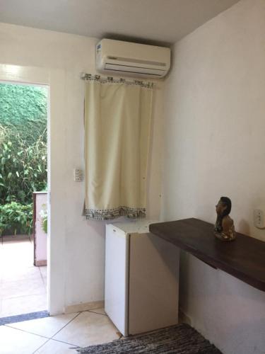 a kitchen with a counter and a refrigerator and a window at Pousada Mar & Vida e Doçaria in Paraty