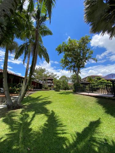 a lawn with palm trees in a park at Finca Hotel La Esperanza in Montenegro