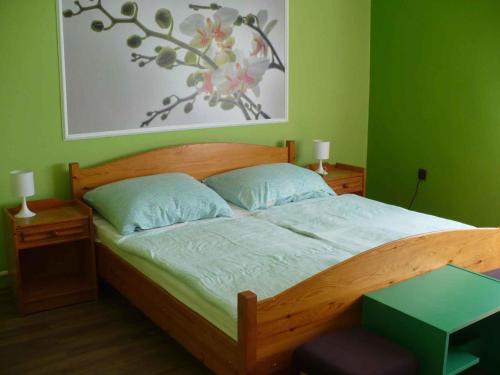 バラトンベレーニにあるHoliday home Balatonbereny/Balaton 18030の緑の壁のベッドルーム1室(木製ベッド1台付)