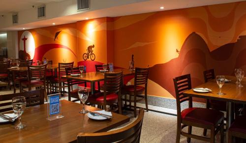 a dining room with wooden tables and chairs at Mar Palace Copacabana Hotel in Rio de Janeiro