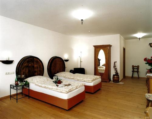 Habitación grande con 2 camas y espejo. en Gästehaus zum Goldberg, en Dorsheim