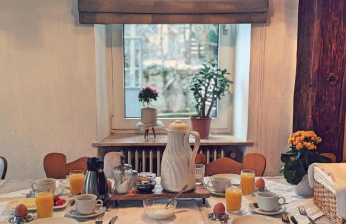 - une table avec un pichet de jus d'orange dans l'établissement Gästehaus zum Goldberg, à Dorsheim