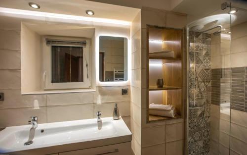 a bathroom with a sink and a mirror and a shower at Mas Saint Antoine in Bourg-Saint-Andéol