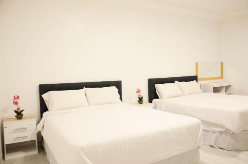 two beds in a room with white walls at Edificio Tofino in Quito