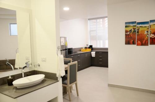 a white bathroom with a sink and a counter at Edificio Tofino in Quito