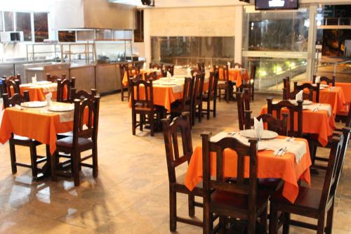 a restaurant with tables and chairs with orange table cloth at Sky Club Eco Hotel in Belén de Umbría