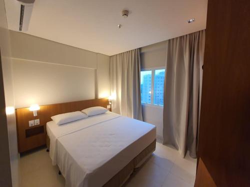 a bedroom with a white bed and a window at SALINAS EXCLUSIVE RESORT in Salinópolis