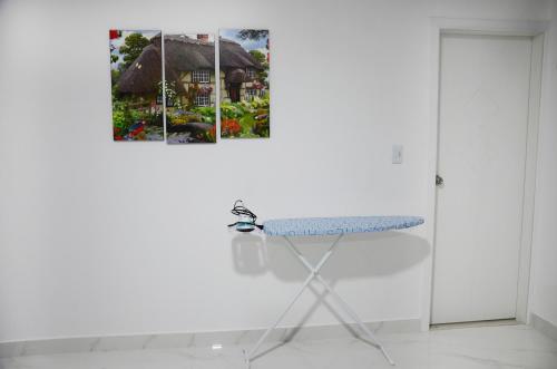 a table in a white room with a picture on the wall at Edificio Tofino in Quito