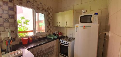 Una cocina con un refrigerador blanco y un microondas. en Casas Pé na Areia - Vista Mar, en Porto de Galinhas