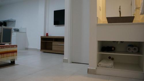 a living room with a television and a kitchen at Edificio Tofino in Quito