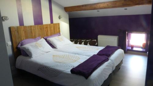 a bedroom with a large bed with purple sheets at La Pause Ardéchoise in Saint-Remèze