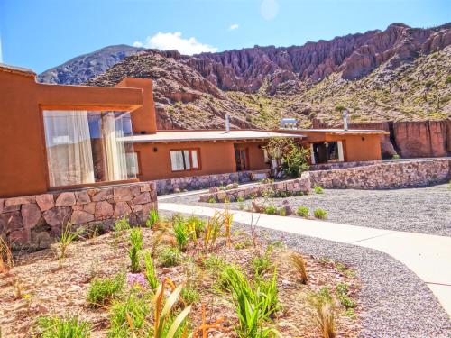 a house with a mountain in the background at Tierra Quebrada Cabañas in Purmamarca