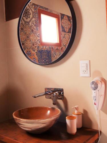 a bathroom with a bowl sink and a mirror at Tierra Quebrada Cabañas in Purmamarca