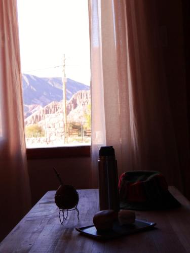 a table with a plate of food and a window at Tierra Quebrada Cabañas in Purmamarca
