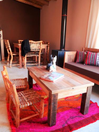 a living room with a wooden table and chairs at Tierra Quebrada Cabañas in Purmamarca
