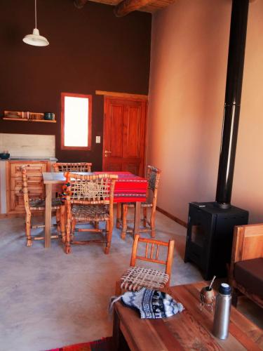 a living room with a table and a stove at Tierra Quebrada Cabañas in Purmamarca